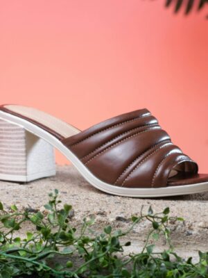 Elegant brown leather heeled sandal showcased on a textured surface with a warm background.